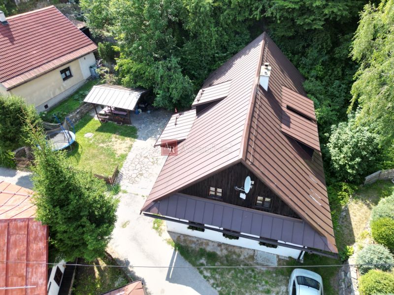 Chata na Španí Dolině v Banské Bystrici s dvorem a zelení v okolí.