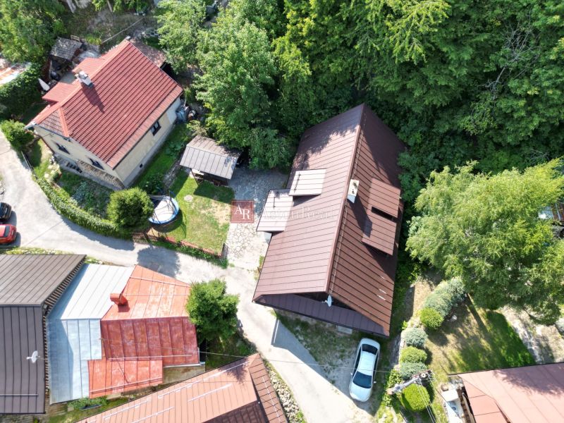 Letecký pohled na chatu ve Španej Dolině u Banské Bystrice obklopenou zelení a domy.