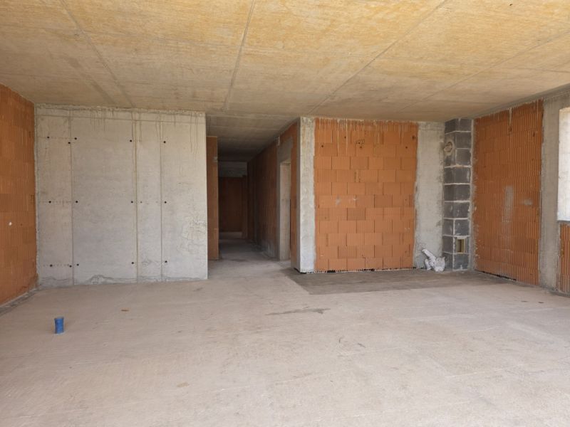 Nedokončené betonové a cihlové stěny ve 4pokojovém bytě.