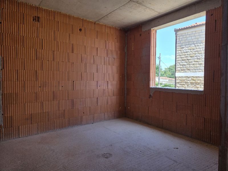 Interiérová stavba ve 4-pokojovém bytě s cihlovými stěnami a betonovou podlahou.