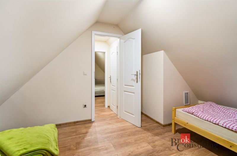 Pokoj na chatě s podlahou s dřevěným dekorem a jednolůžkem.