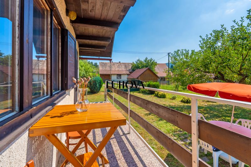 Balkon chaty na Dubkové ulici v Lazy pod Makytou s výhledem na upravenou zahradu.