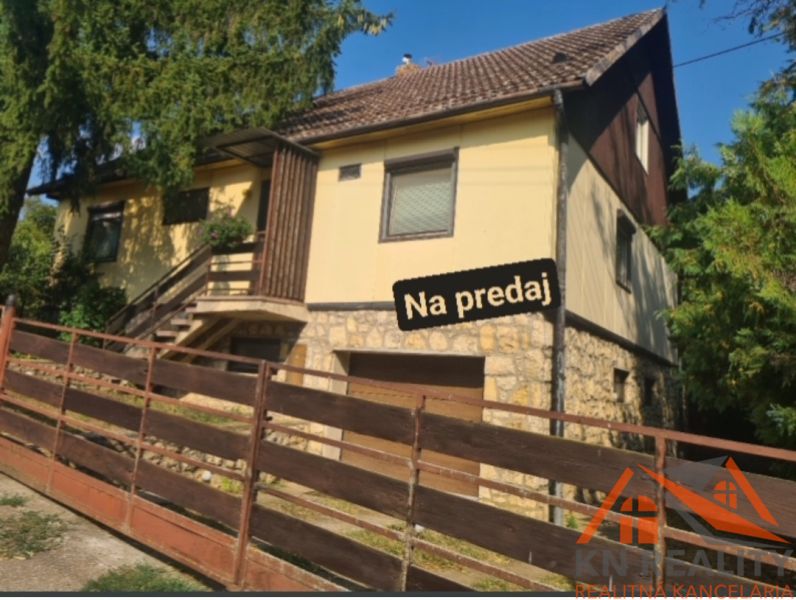 Rodinný dům ve Svodíně, s kamennými základy a dřevěným plotem, je na prodej.