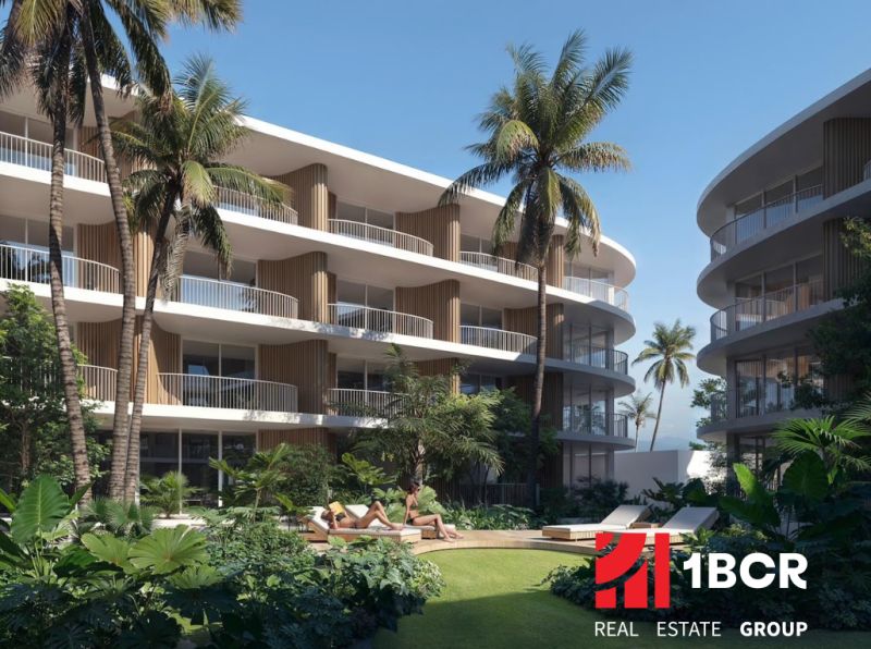 Výstavba bytů v Surat Thani: bytové budovy s palmami a zelení na pozadí.