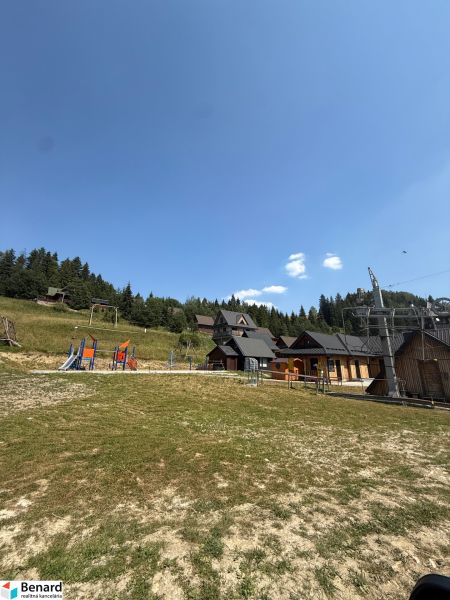 Rekreační pozemky v Litmanové s dětským hřištěm a okolními lesy.