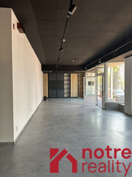 Prostorné kanceláře s velkými okny a dekorativní podlahou.