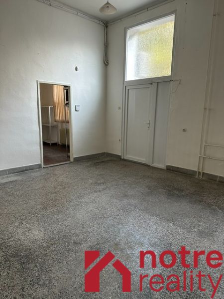 Interiér kanceláře s bílými stěnami a podlahou v dekoru betonového efektu.