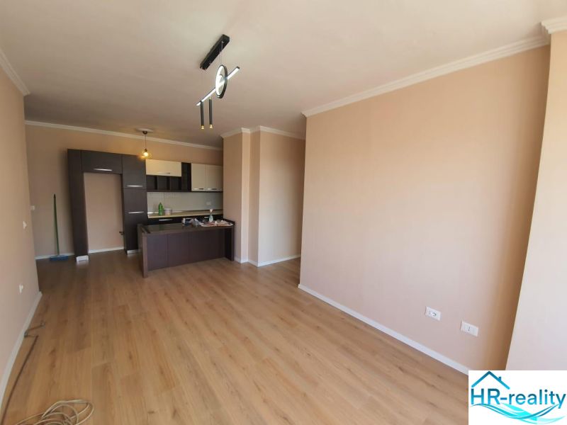 Obývací prostor s kuchyňským koutem a podlahou s dřevěným dekorem v Rekreačním apartmánu.
