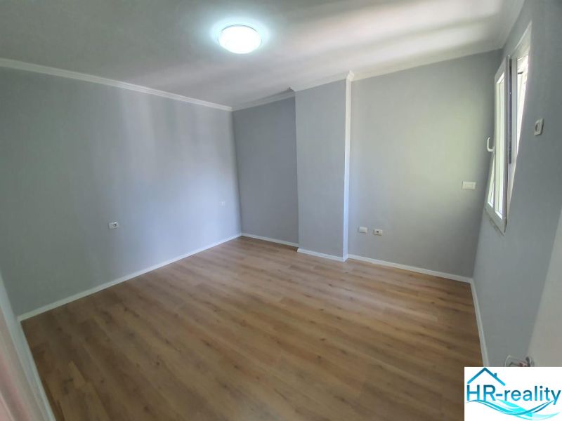 Světlý pokoj s podlahou s dřevěným dekorem v Rekreačním apartmánu.