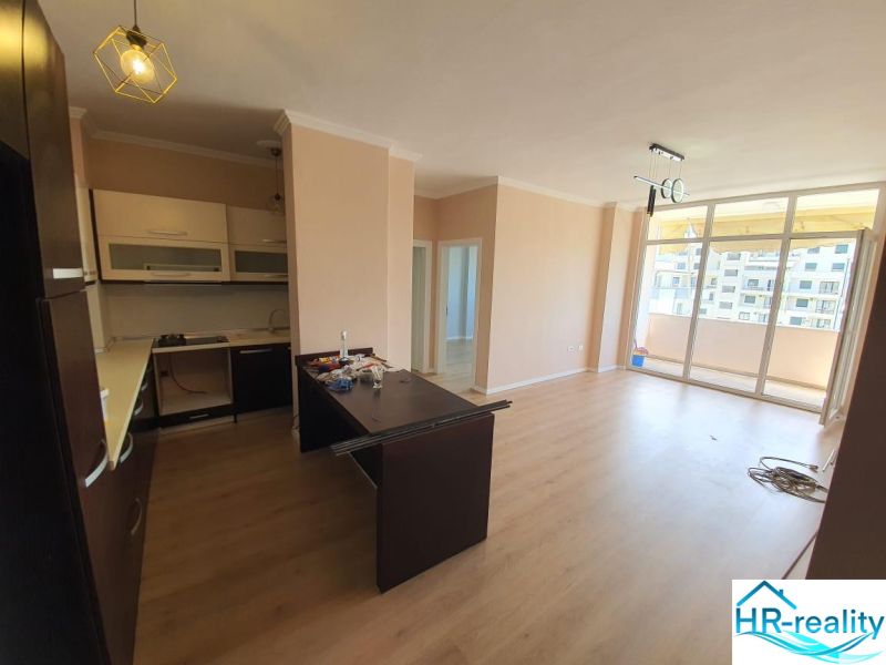Kuchyně a obývací pokoj v rekreačním apartmánu, podlaha s dřevěným dekorem, balkon.