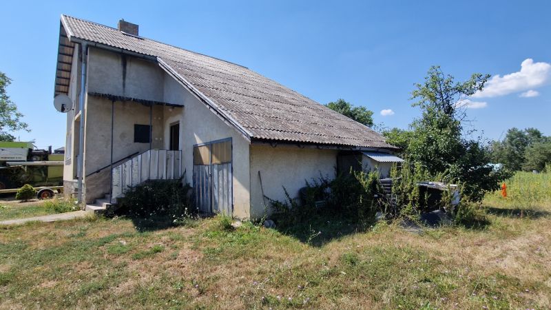Rodinný dům na Bílé ulici v Kazimíru s jednoduchou fasádou a zarostlým pozemkem.