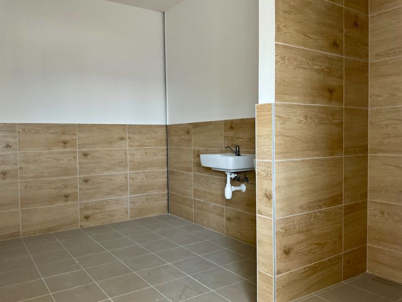 Prostor se stěnami v dekoru dřeva a umyvadlem ve skladech a halách.