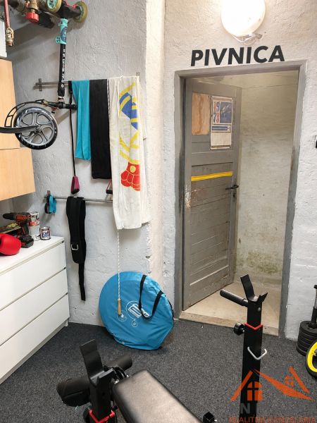 Cvičební kout s posilovacím zařízením a úložnými prvky, vhodný do 3-pokojového bytu.