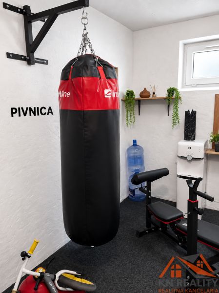 Sklep 3pokojového bytu s boxovacím pytlem a cvičebním zařízením.