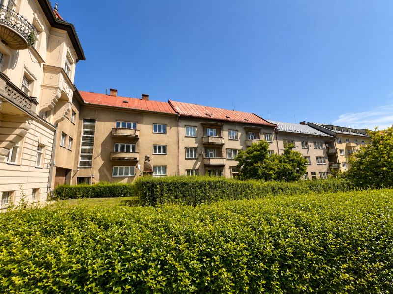 Bytové domy s balkóny a zelení na Národní ulici v centru města.