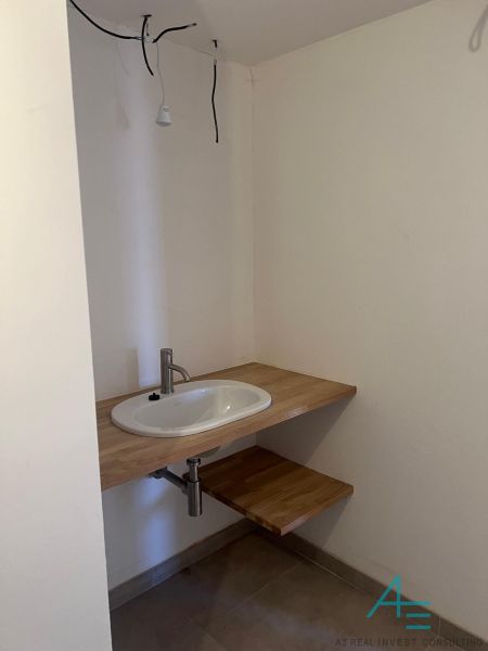 Umyvadlo se stolovou deskou z dřevěného dekoru v koupelně rodinného domu.