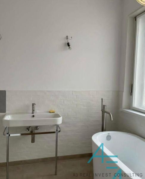 Koupelna s vanou a umyvadlem v rodinném domě s jednoduchým designem.