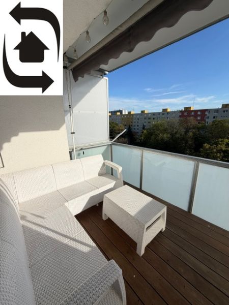 Balkon s bílým nábytkem a výhledem na sídliště v Bratislavě - Ružinově na Muškátové.