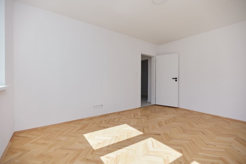 Světlá místnost s bílými stěnami a podlahou s dřevěným dekorem, 3-pokojový byt.