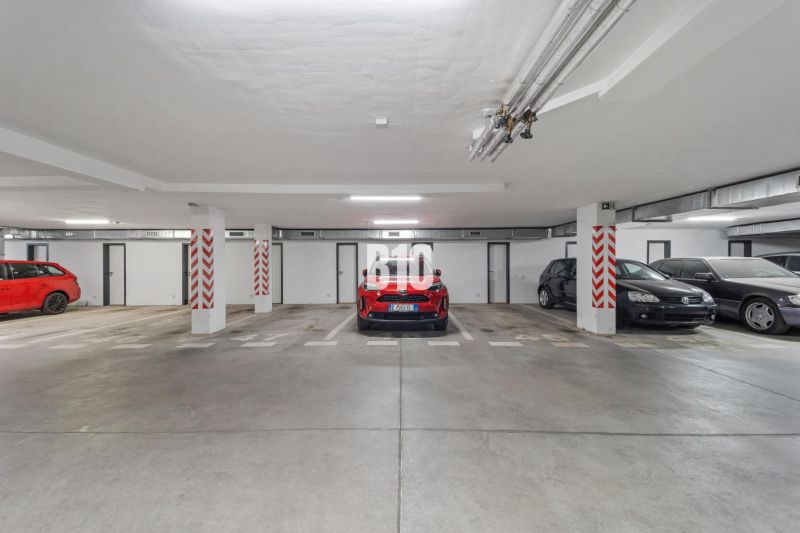 Podzemní garáž se zaparkovanými auty ve 4-pokojovém bytě v Nitře, betonová podlaha.
