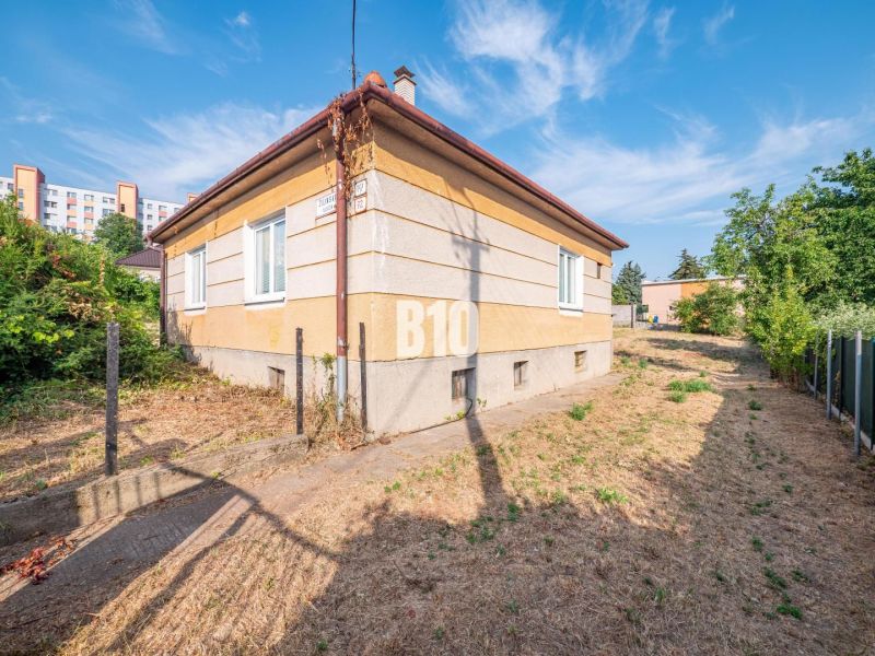 Rodinný dům v Nitře s travnatým okolím, u něj vede úzká cesta.