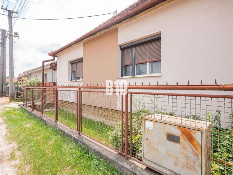 Rodinný dům v Nitře s oplocením vedle elektroinstalací a vegetací na pozemku.