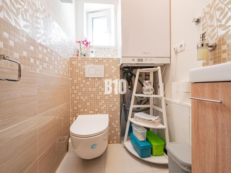 Koupelna v rodinném domě s kachličkami a moderním vybavením.