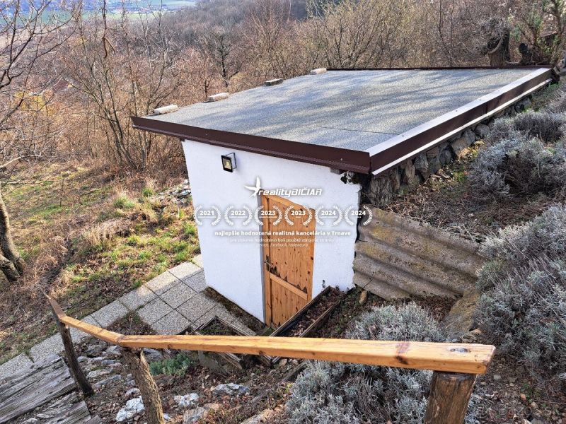 Malá chata se šikmou střechou v Dolních Orešanech na kopcovité ulici Dolní Orešany.