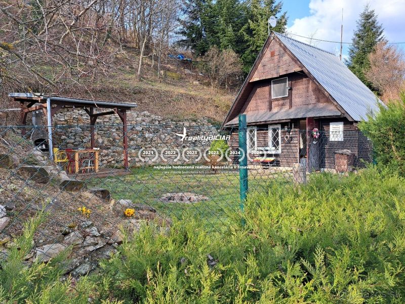 Chata s dřevěným dekorem v obci Dolní Orešany, na ulici Dolní Orešany, obklopená přírodou.