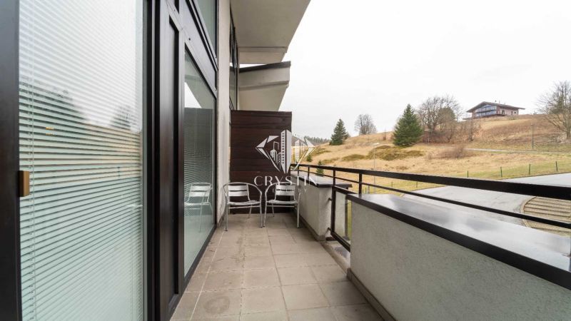 Balkón rekreačního apartmánu na Donovalech s výhledem na přírodu a chaty.