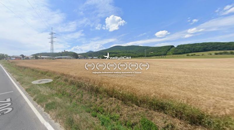 Zemědělské a lesní pozemky na Tovární ulici ve Smolenicích s výhledem na kopce.