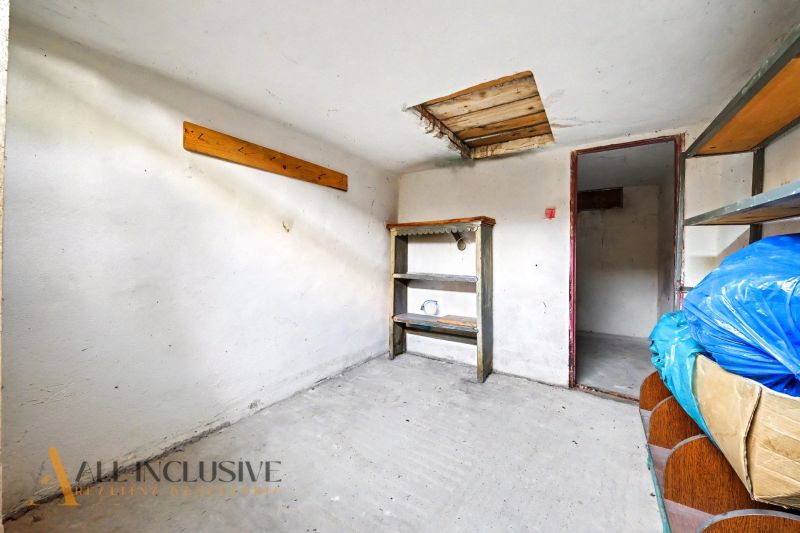 Minimalistická místnost s regály v 3-pokojovém bytě, betonová podlaha, neutrální interiér.