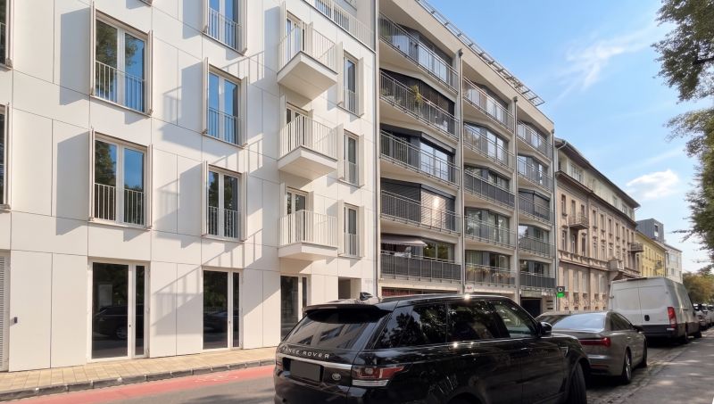 Ulice Banskobystrická, Bratislava - Staré Město, zobrazuje moderní fasádu budov a zaparkovaná auta.