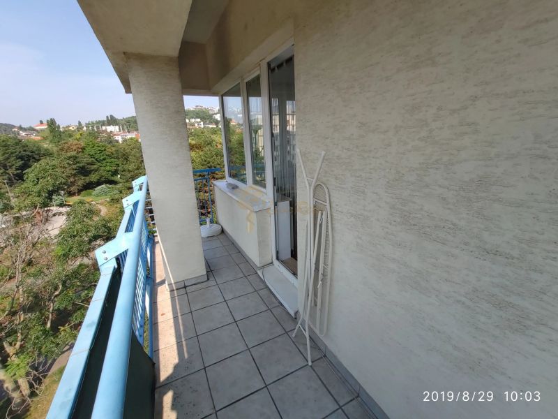 Balkon 2-pokojového bytu s modrým zábradlím a výhledem na zeleň v Bratislavě.