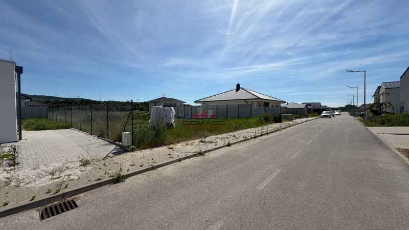 Ulice Ducovská v Moravanech nad Váhem s rodinným domem, auty a ploty.
