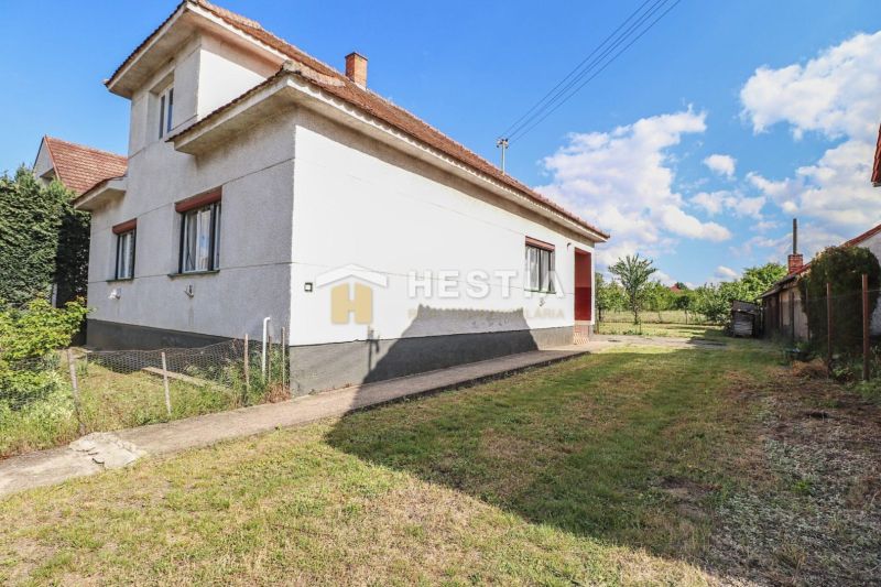 Rodinný dům v Borském Mikuláši s travnatým pozemkem a modrou oblohou.