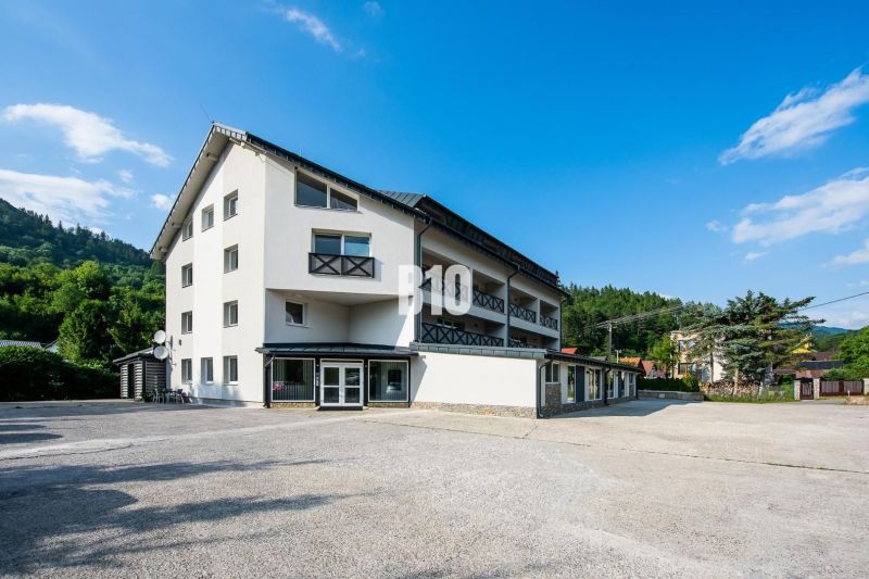 Exteriér rekreačního apartmánu v Terchové s jasnou oblohou a zelení kolem.