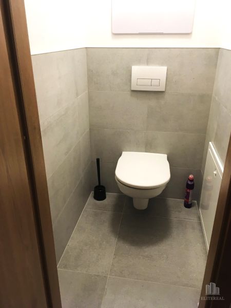 Koupelna v 2-pokojovém bytě s dlažbou a závěsným WC.