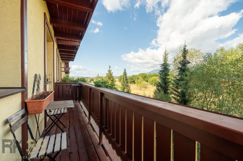 Balkon 2-pokojového bytu ve Velké Lomnici s výhledem na přírodu a stromy.