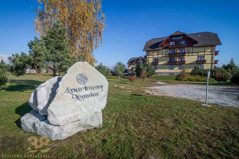 Bytový komplex ve Velké Lomnici, na travnaté ploše s velkým kamenným nápisem.