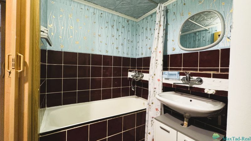 Koupelna se smaltovanou vanou a kachličkovanými obklady ve 4-pokojovém bytě.