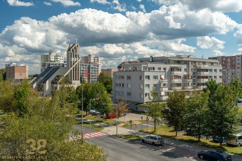Pohled na ulici Ludvíka Svobody v Popradu se sakrální stavbou a bytovkami.