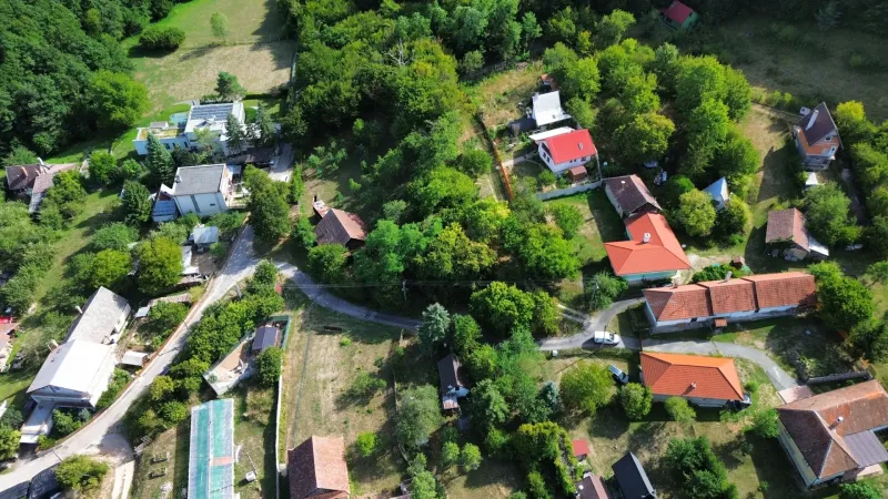 Letecký pohled na malebné Zahrady v Kolačně s roztroušenými domy a zelení.