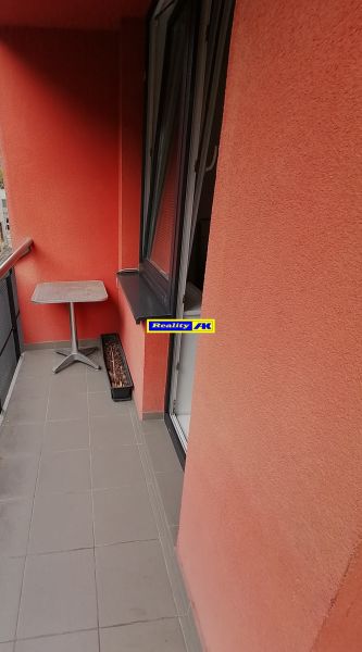 Balkon s červenými stěnami ve 2-pokojovém bytě na Nábrežní ulici ve Vrútkách.