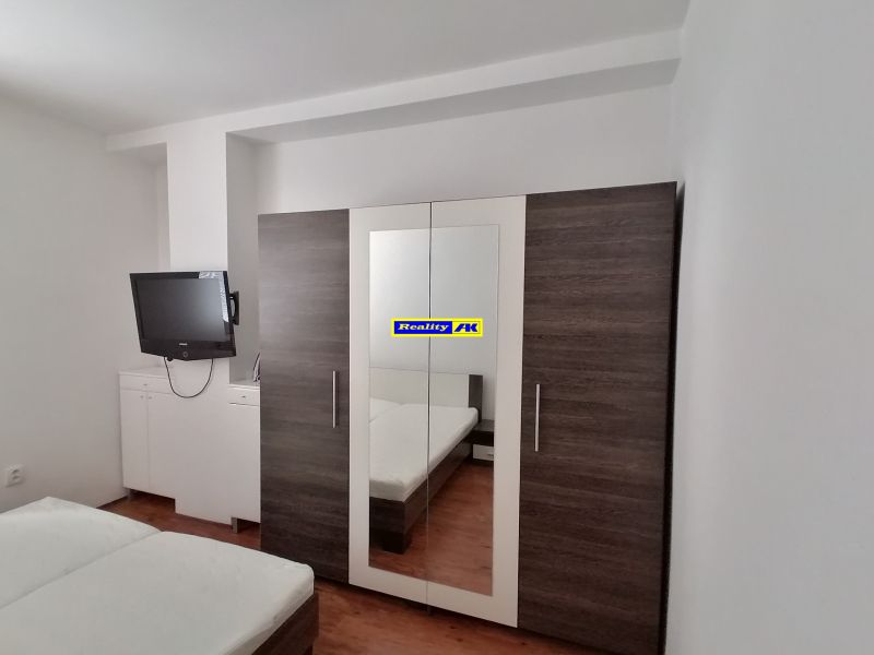 Ložnice s televizí, šatní skříní a postelí, 2pokojový byt.