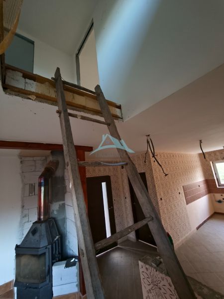 Rekonstrukce interiéru v rodinném domě, dominují schody a kamna na dřevo.