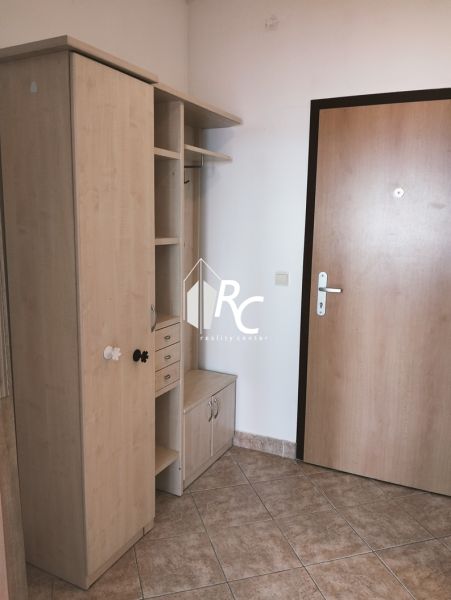 Vstupní chodba se skříňkami a věšákovou stěnou v 2-pokojovém bytě.
