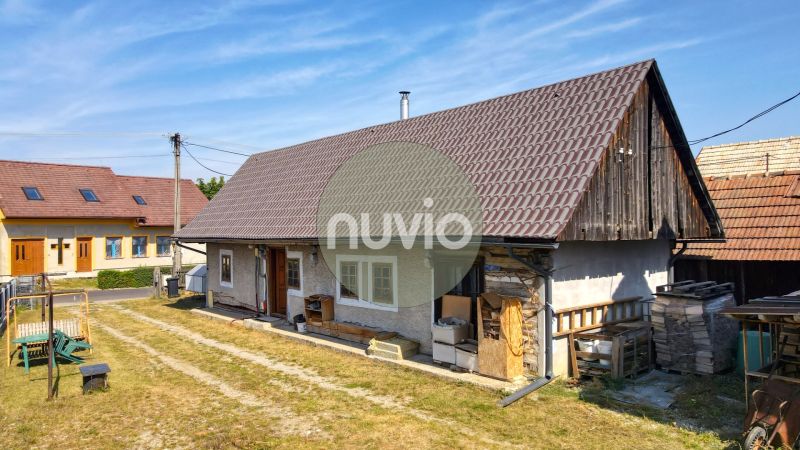 Rodinný dům v Žabokrekách s velkou střechou, dřevěnými detaily a dvorem.