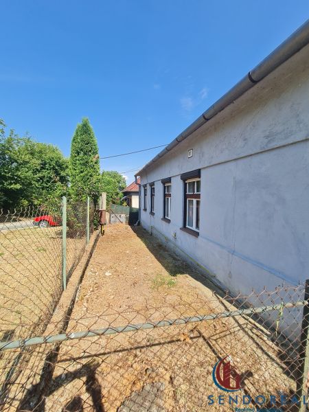 Rodinný dům v Dolních Otrokovicích s oplocením a příjezdovou cestou na dvoře.
