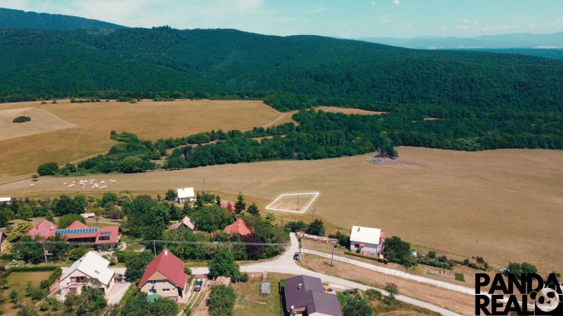 Venkovský pohled na pozemky k bydlení v Podhradí obklopené lesy a loukami.